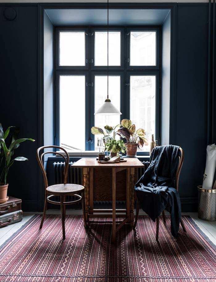 Dining Table Near Window With Dark Blue Wall