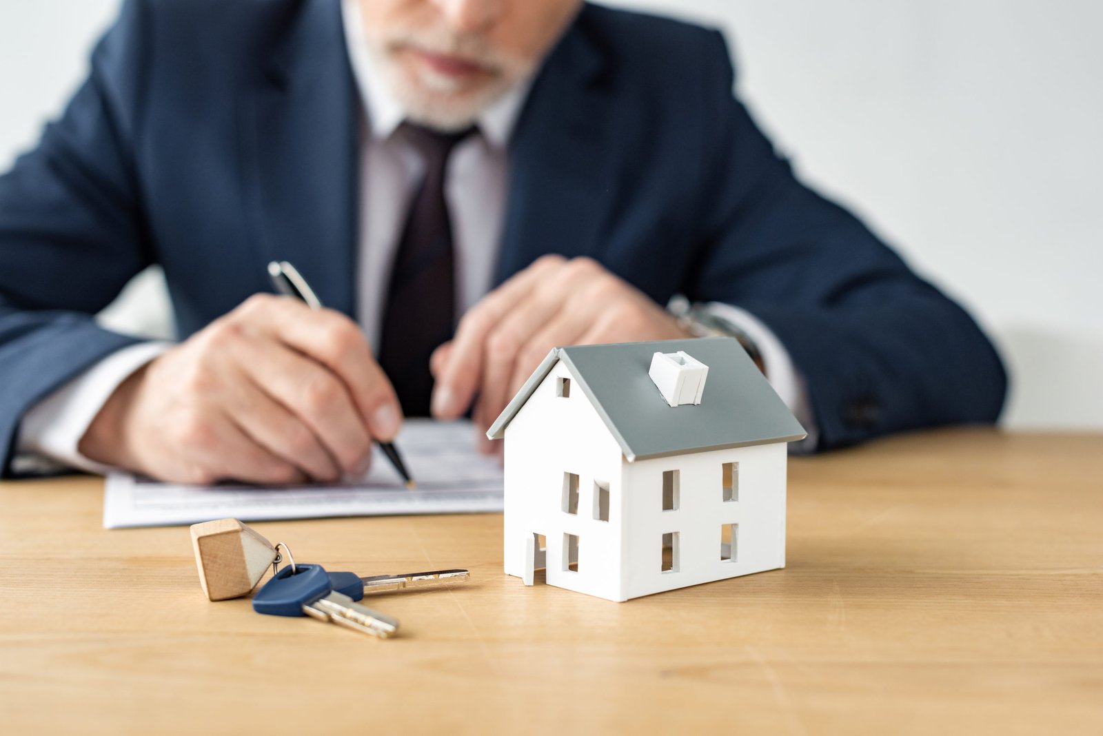 selective focus of house model near keys and house dealer